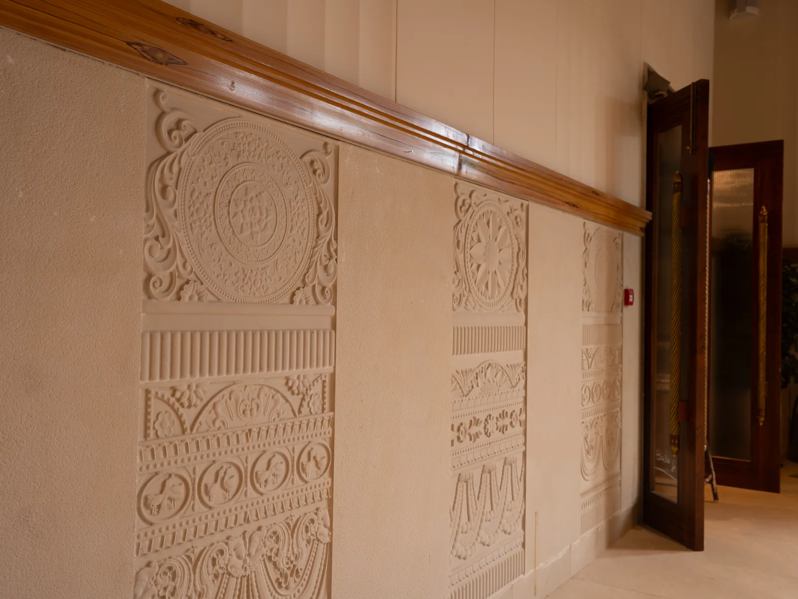 Carved stone-effect wall panels with timber rail — Chalukya Samrat
